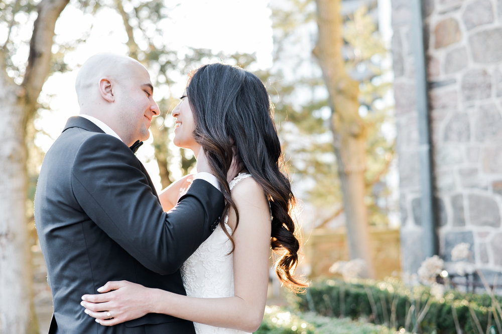 Couple kiss on the terrace of Graydon Hall at their spring wedding.