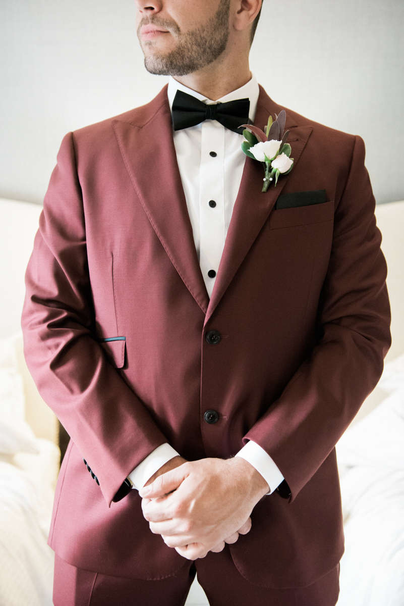 groom in burgundy suit