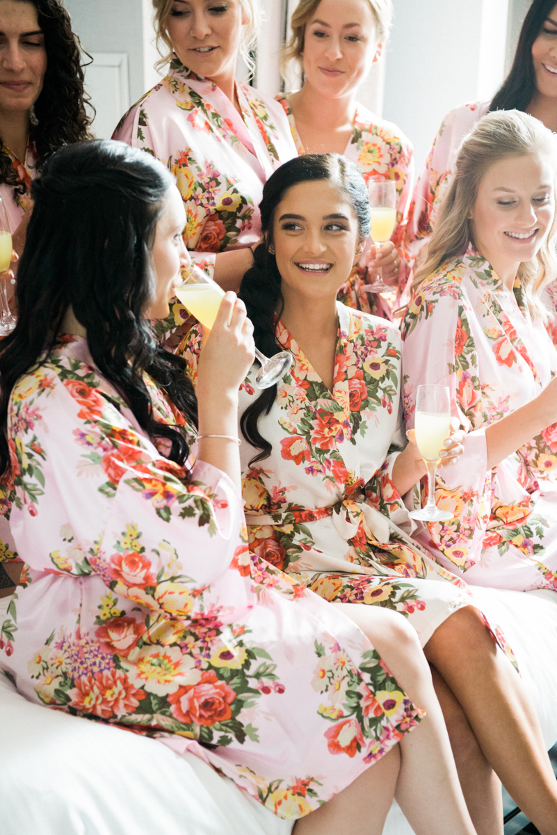 bridemaids having champagne in pink robes