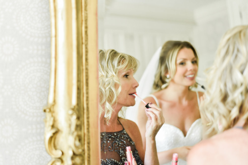 Mom and bride put on makeup in a gold mirror
