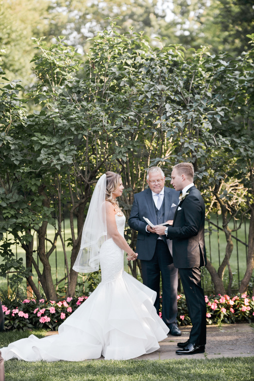 Saying vows in an outdoor ceremony at Graydon HAll