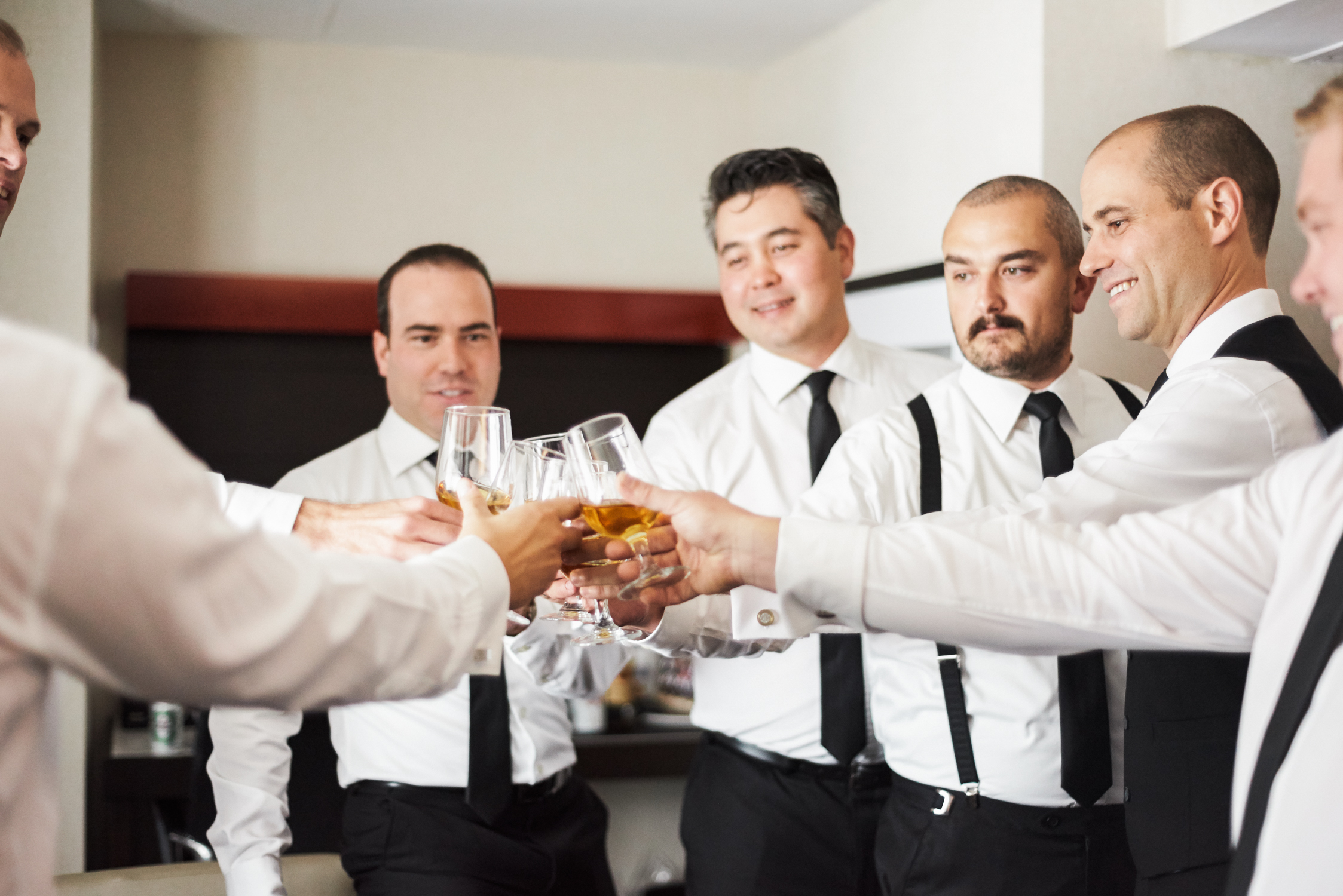 Groomsmen cheers with whiskey