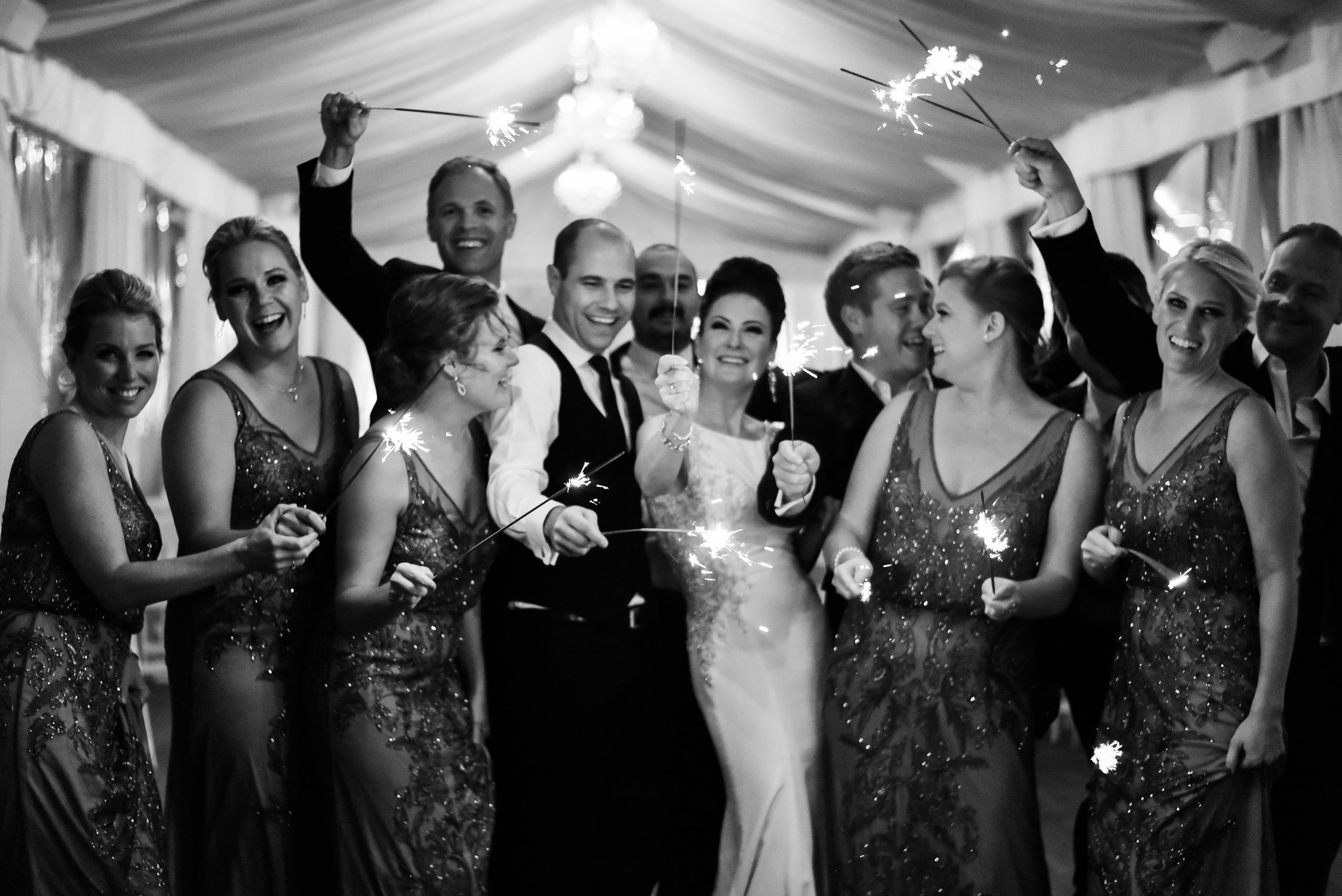 Black and white photo of bride and groom and their wedding party with sparklers at malaparte in Toronto