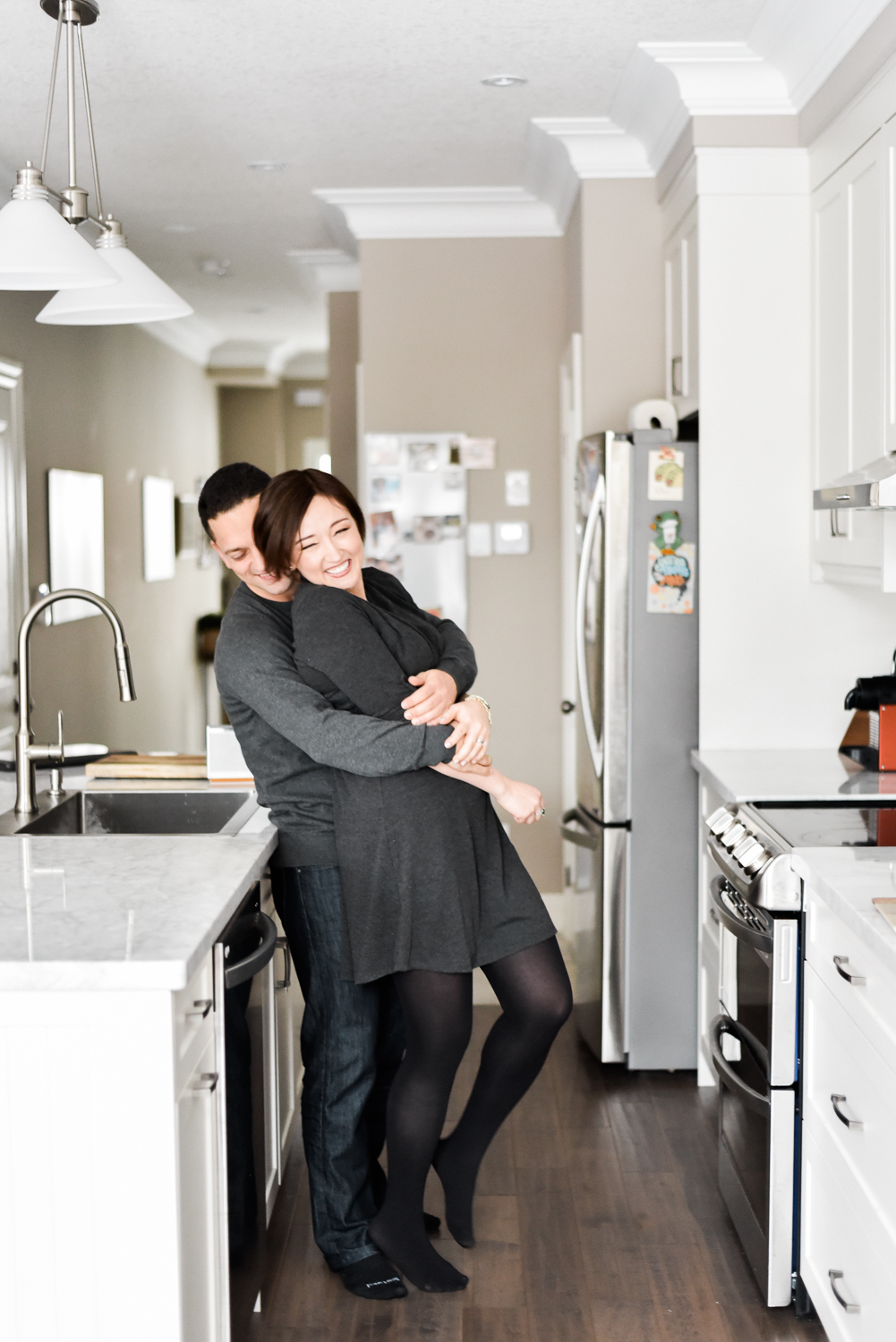 Candid engagement photo in kitchen with couple