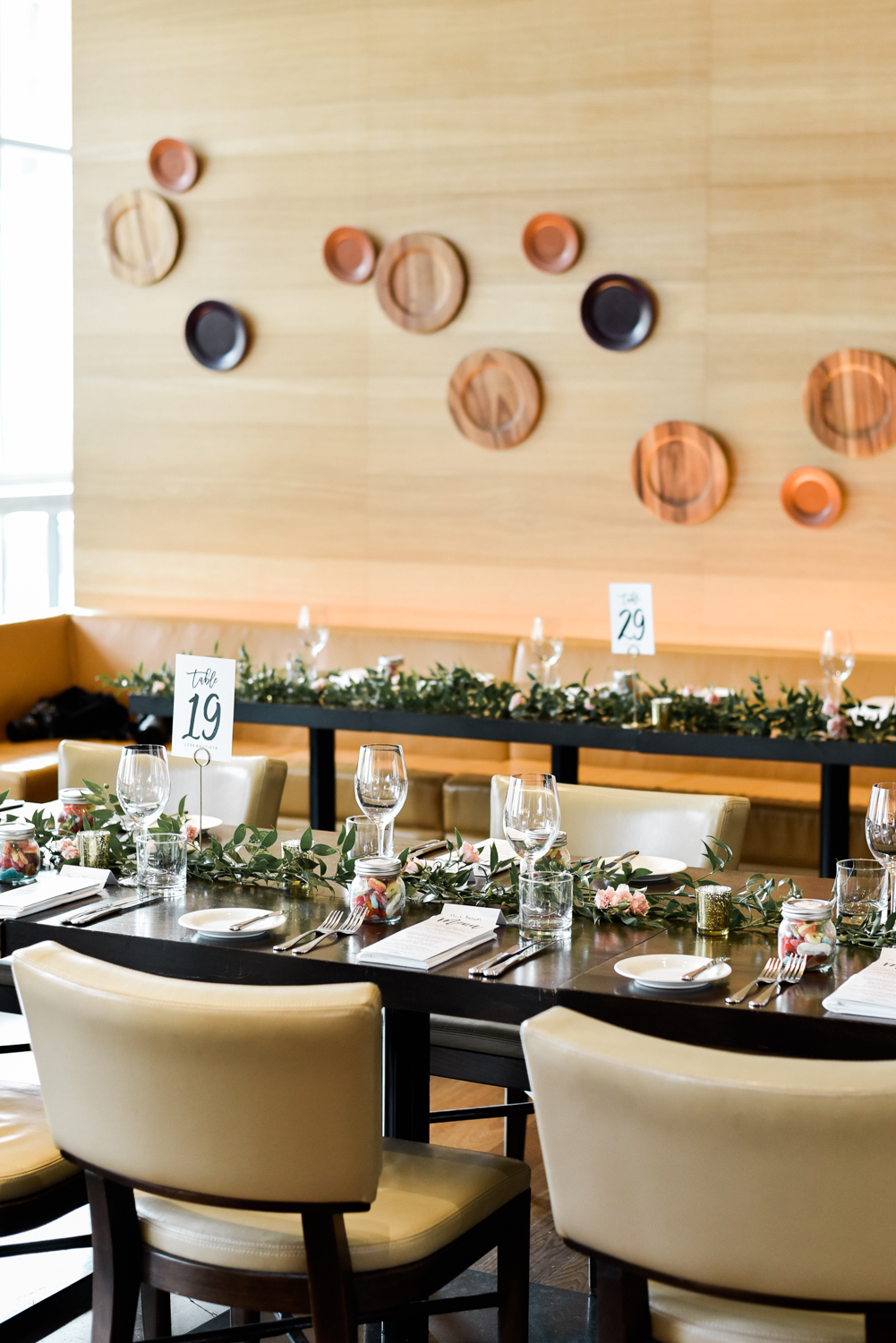 Wedding table decor at Luma Restaurant by Cool Green and Shady. Simple green garlands and Jays themed table numbers.
