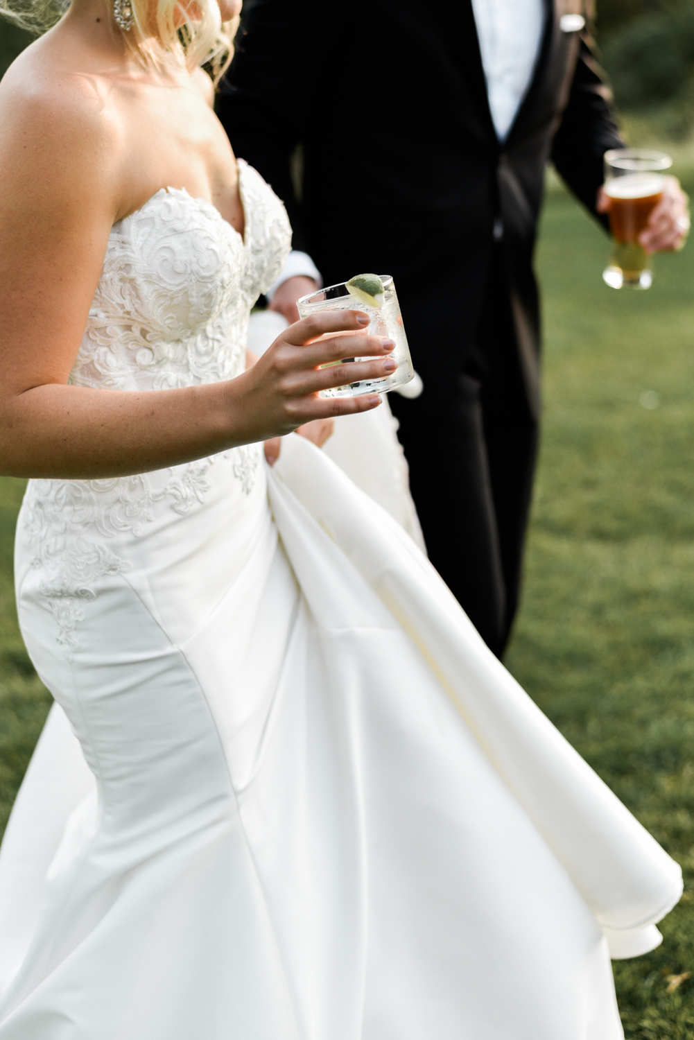 Close up of bride holding a rocks glass at her summer wedding