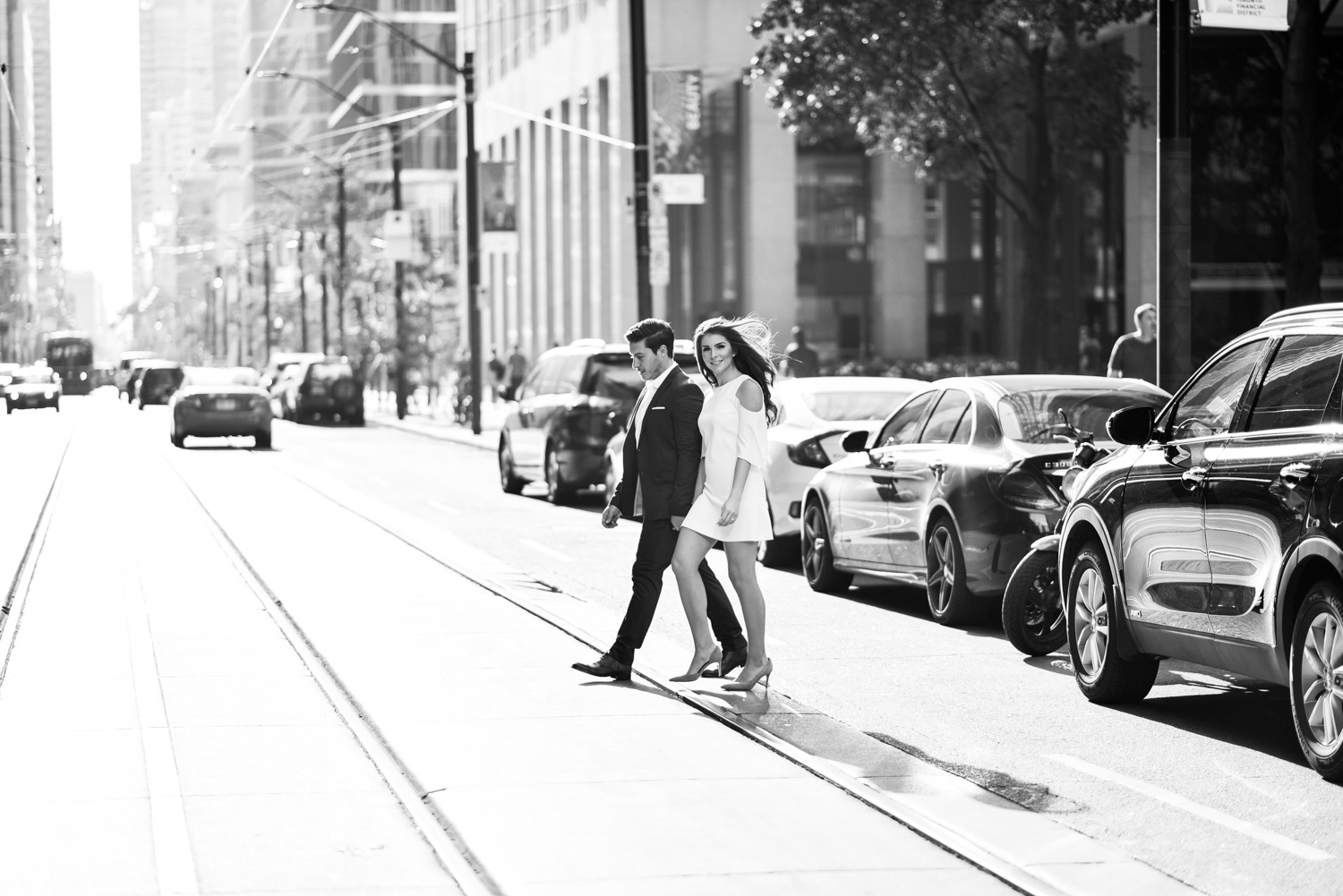 Man and woman in white dress crossing king street engagement shoot