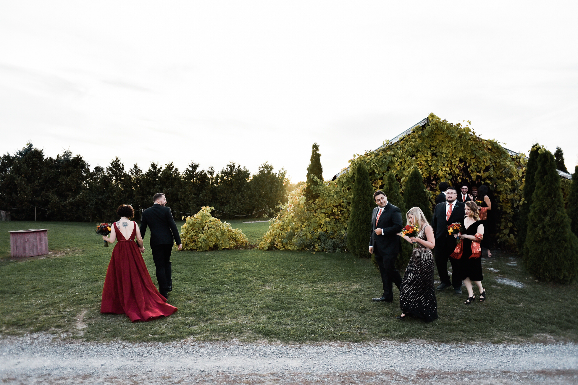 Bridal party exit the barn at fields on west lake for this sunset, autumn wedding