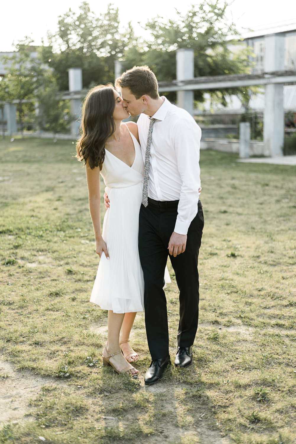 Girl in white dress kissing man in white shirt