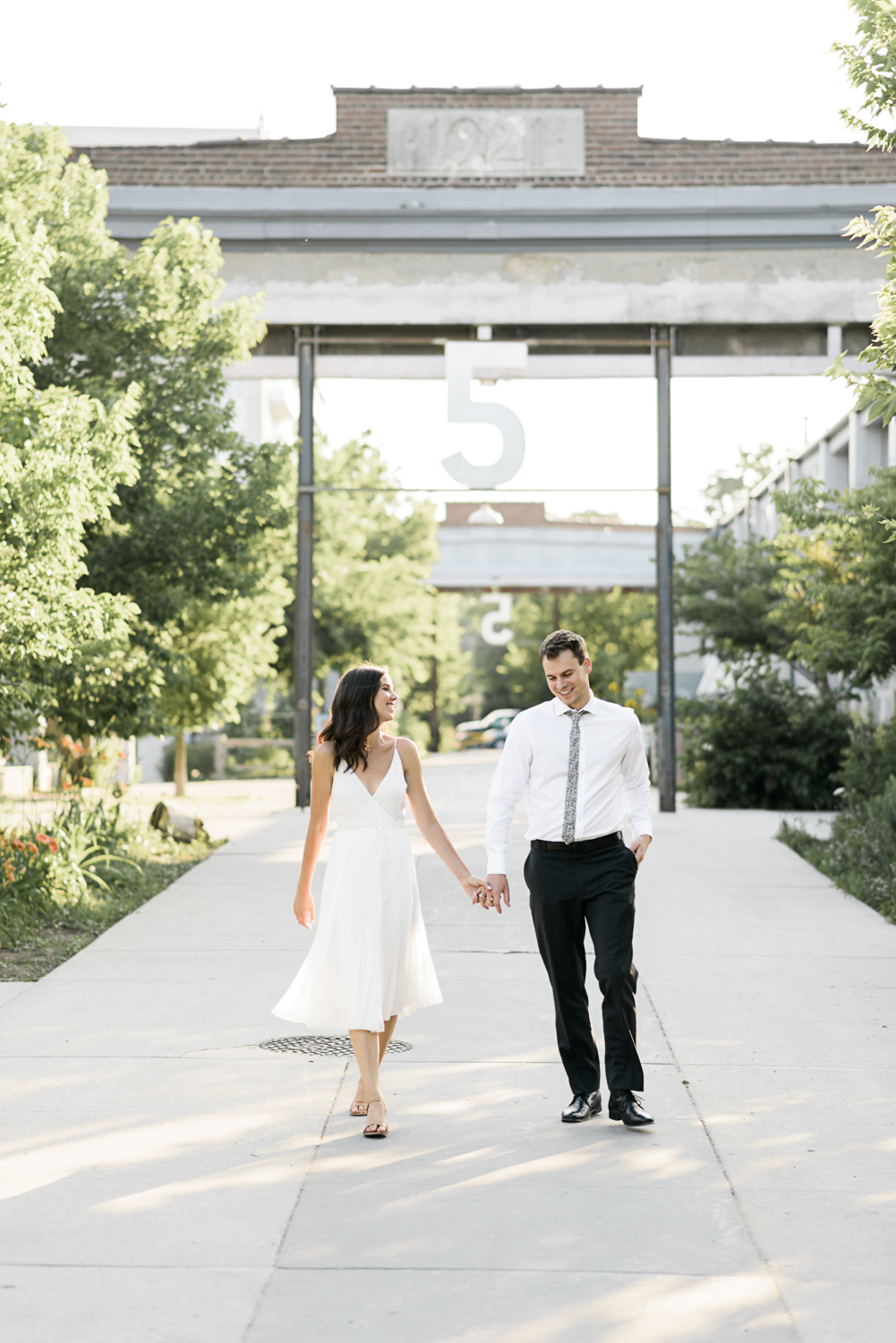 Couple dressed in white at the Wychwood Barns for their engagement shoot