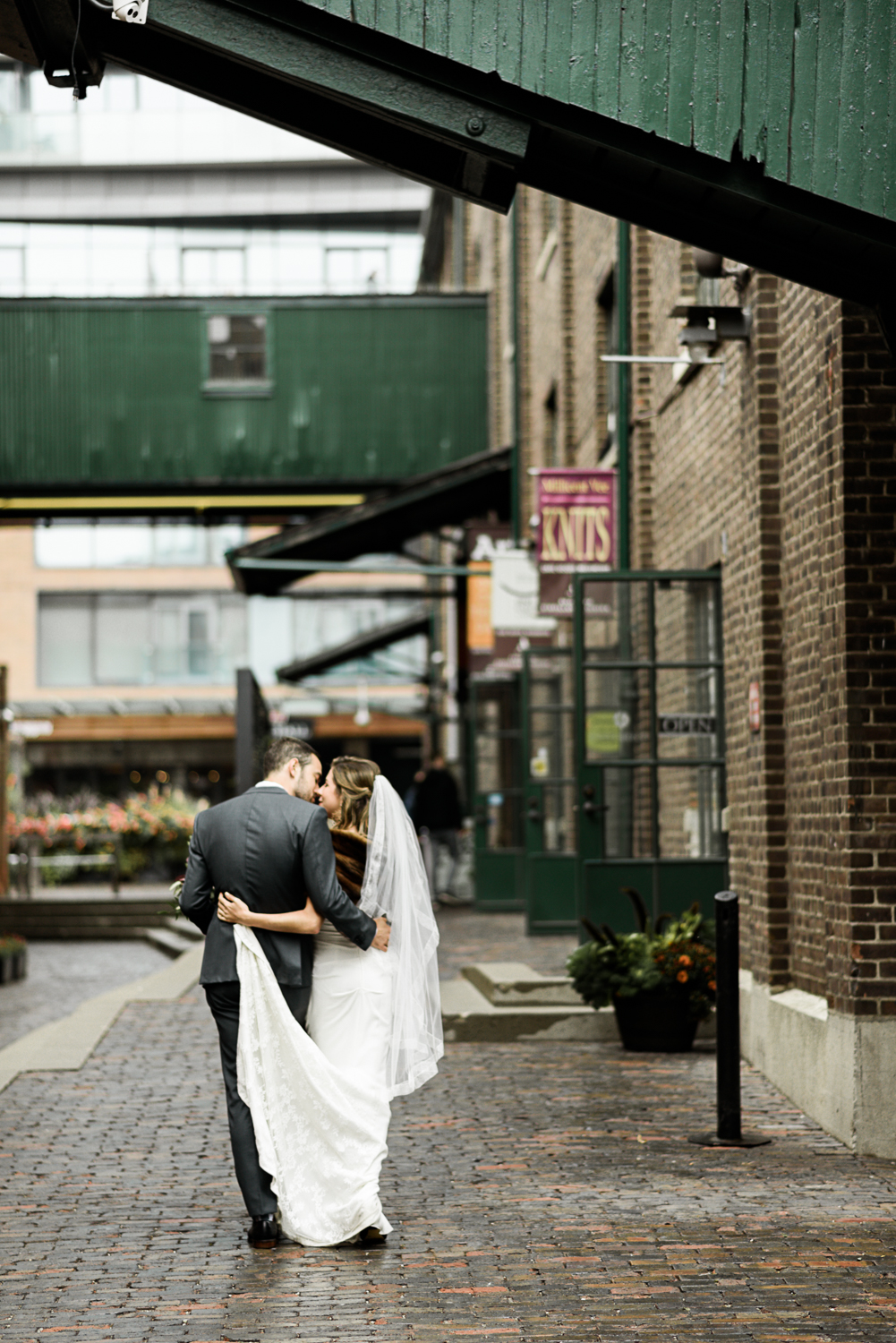 Bride and groom embrace at the distillery district for their wedding photos