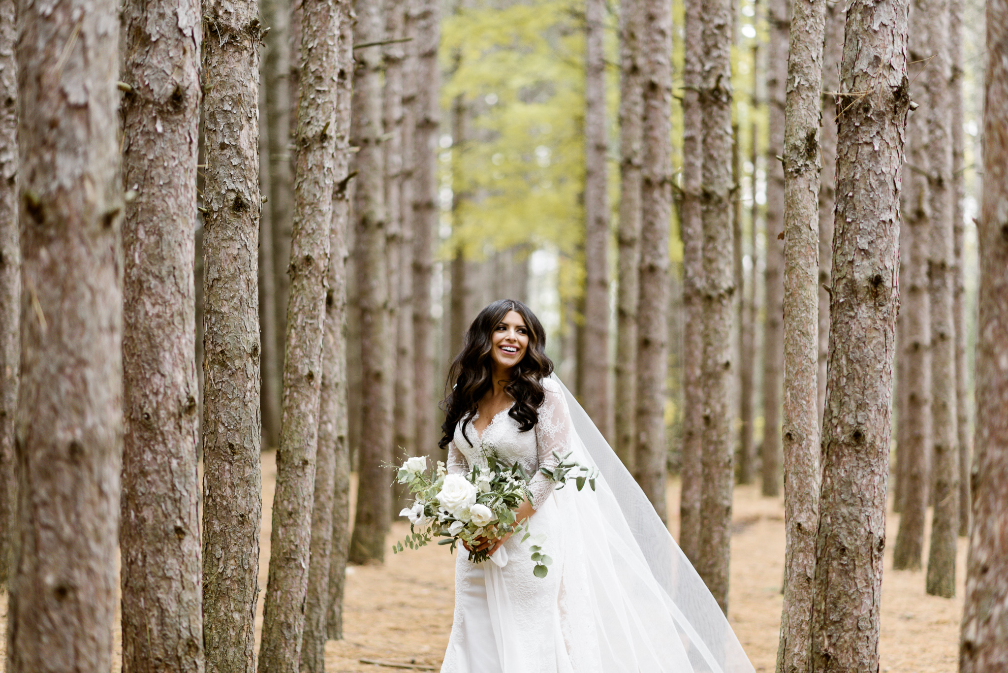 A bride smiles in the forest of Kortright Centre